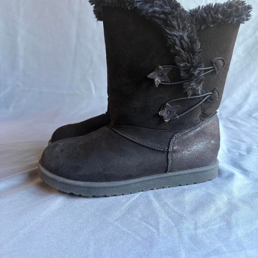 Black faux fur lined boots with star-shaped buckle details